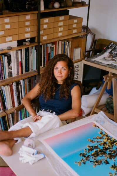 Lily Bertrand-Webb sits in her photography studio with one of her prints.